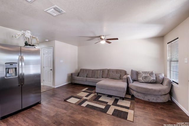 living room featuring ceiling fan, a textured ceiling, and dark hardwood / wood-style flooring