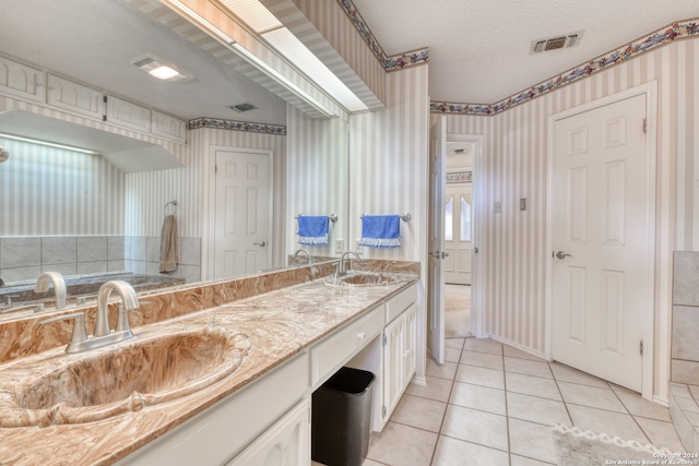 bathroom with vanity, tile patterned floors, and a textured ceiling