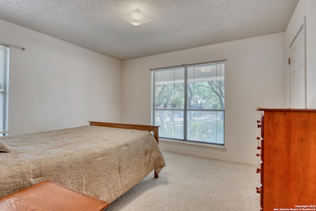 carpeted bedroom featuring a textured ceiling