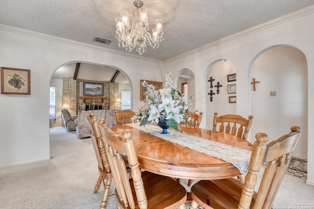 dining room featuring crown molding, a textured ceiling, light colored carpet, and a fireplace