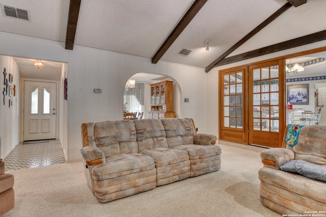 living room featuring a textured ceiling, vaulted ceiling with beams, and light colored carpet