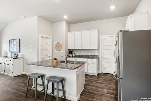 kitchen with dark hardwood / wood-style floors, sink, a center island with sink, and stainless steel refrigerator