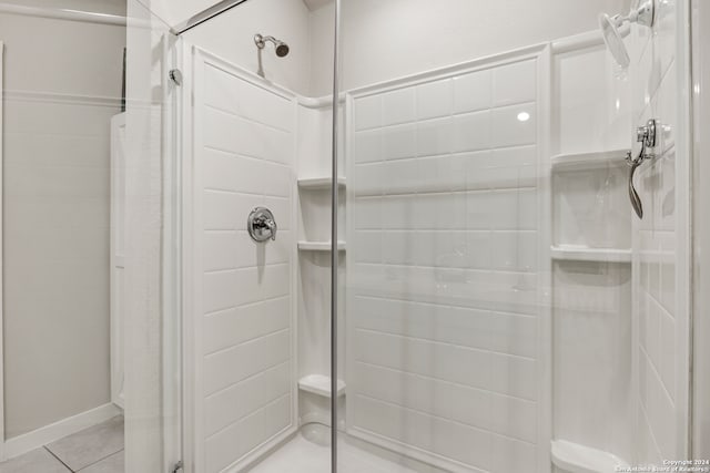 bathroom with a shower with shower door and tile patterned flooring