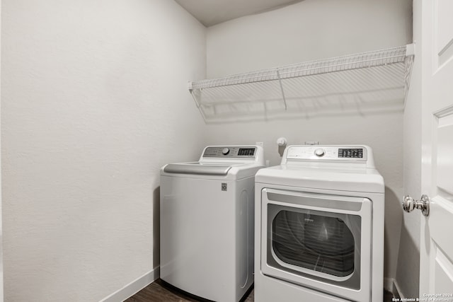 clothes washing area featuring dark hardwood / wood-style floors and washer and clothes dryer