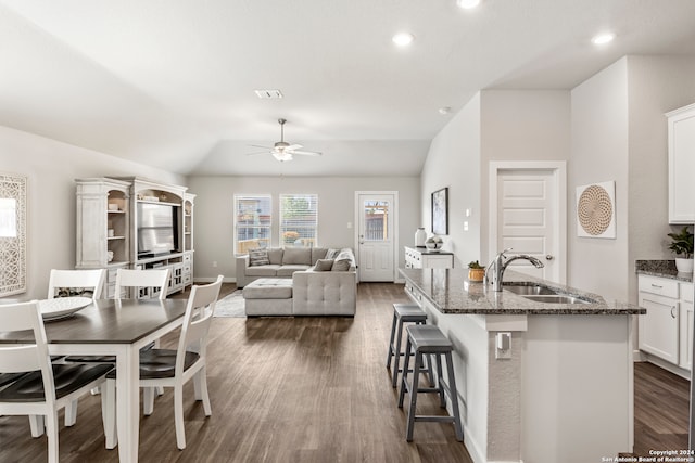 kitchen featuring an island with sink, white cabinetry, sink, and dark hardwood / wood-style floors