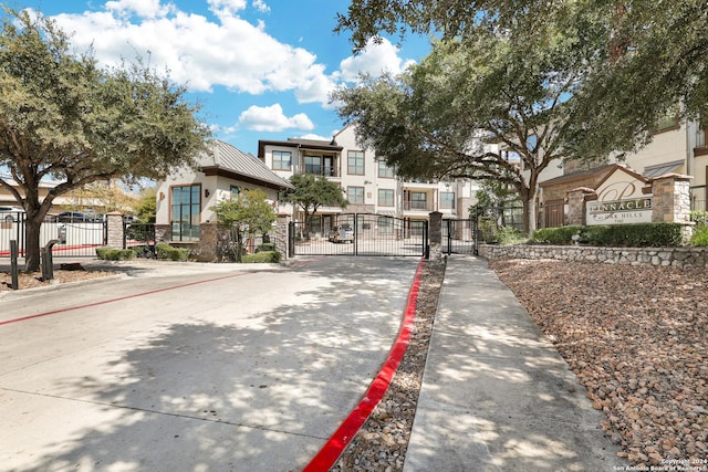 7342 Oak Manor Dr Unit 1204, San Antonio, TX 78229 - view of front facade with a gate, stucco siding, a residential view, and a standing seam roof