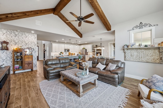 living room featuring beam ceiling, hardwood / wood-style floors, ceiling fan with notable chandelier, and high vaulted ceiling