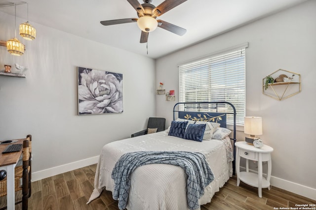 bedroom featuring wood-type flooring and ceiling fan with notable chandelier