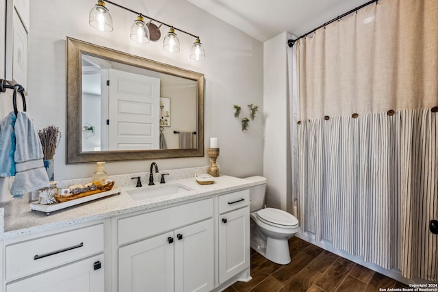 bathroom with vanity, toilet, and wood-type flooring