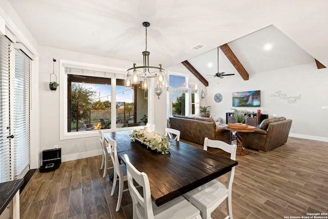 dining area with dark wood-type flooring, lofted ceiling with beams, a wealth of natural light, and ceiling fan with notable chandelier