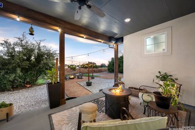 patio terrace at dusk with an outdoor fire pit and ceiling fan