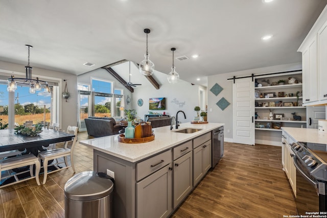 kitchen featuring black electric range oven, dark hardwood / wood-style flooring, a barn door, dishwasher, and sink