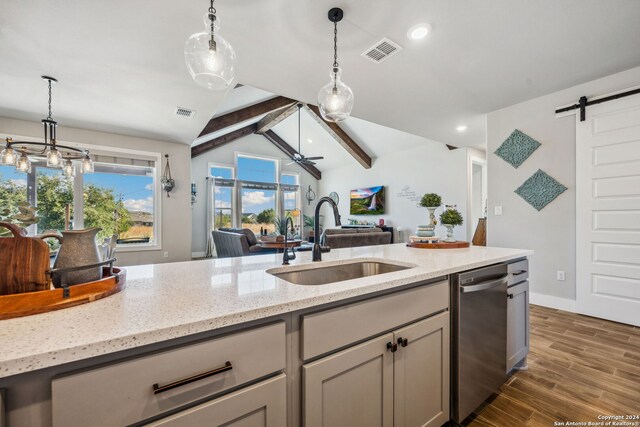 kitchen featuring vaulted ceiling with beams, dark hardwood / wood-style floors, sink, light stone countertops, and a barn door