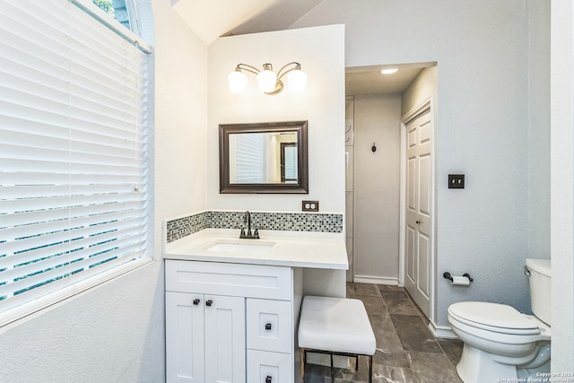 bathroom with vanity, lofted ceiling, and toilet