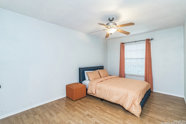 bedroom with light hardwood / wood-style flooring and ceiling fan