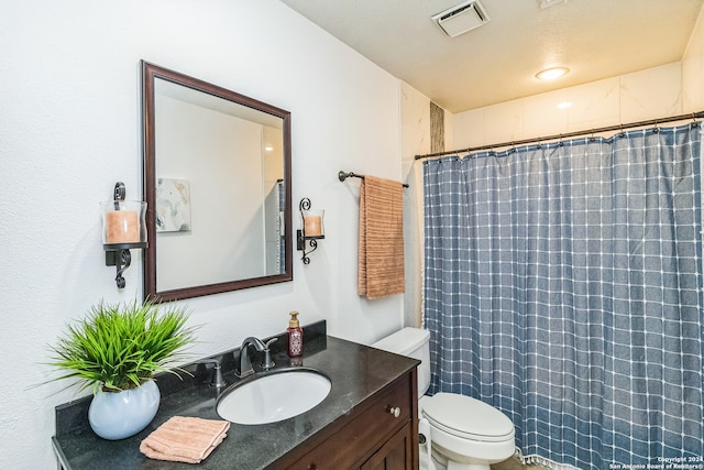 bathroom with vanity, a shower with shower curtain, and toilet