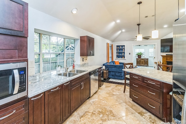 kitchen featuring ceiling fan, vaulted ceiling, stainless steel appliances, pendant lighting, and sink