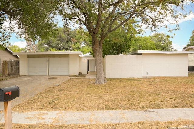 ranch-style house with central AC, a front lawn, and a garage