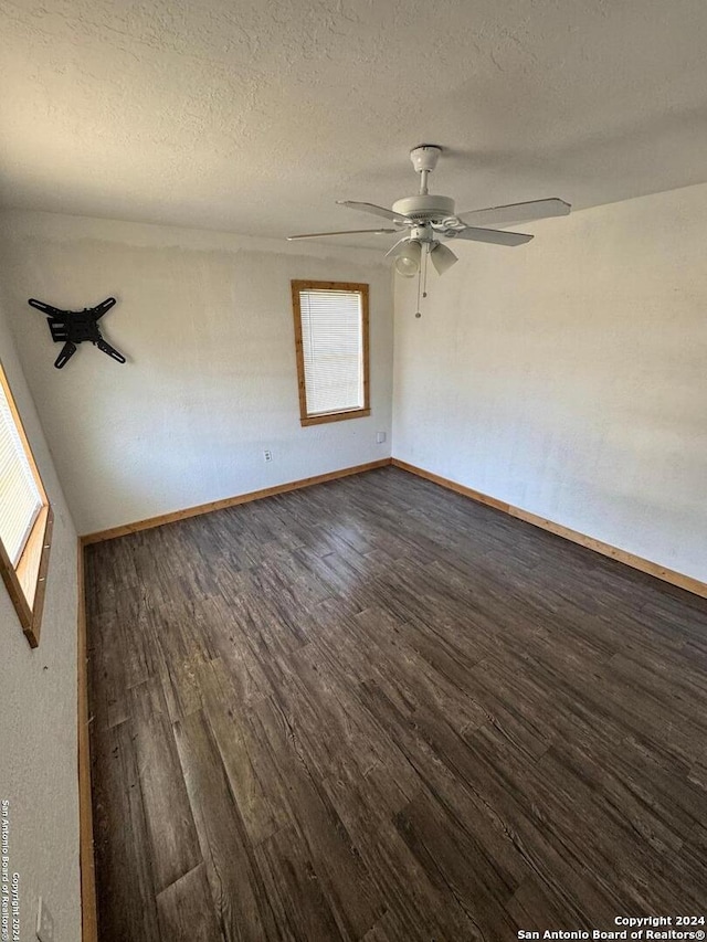 empty room with ceiling fan, a textured ceiling, and dark hardwood / wood-style flooring