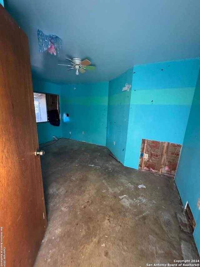 spare room featuring ceiling fan and concrete flooring