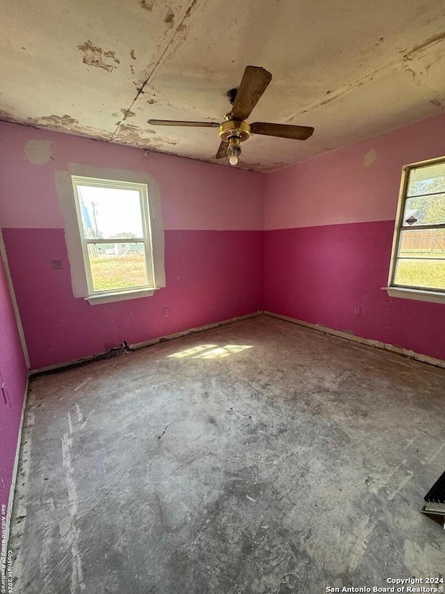 empty room featuring ceiling fan and a wealth of natural light