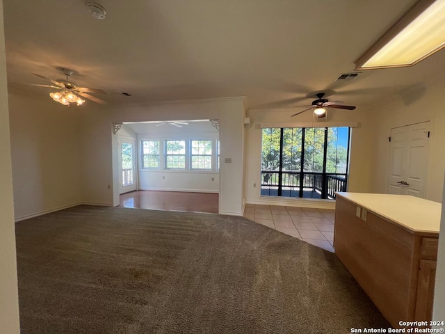 unfurnished living room with light carpet, a wealth of natural light, and ceiling fan