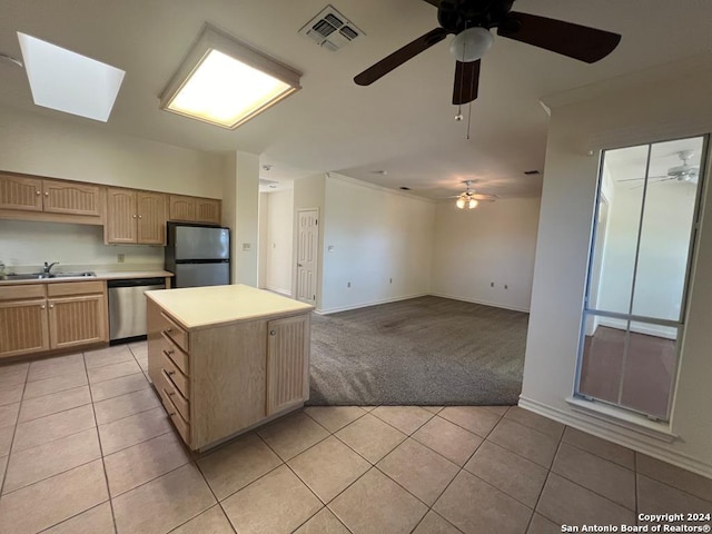 kitchen with appliances with stainless steel finishes, light brown cabinets, sink, and light tile patterned flooring