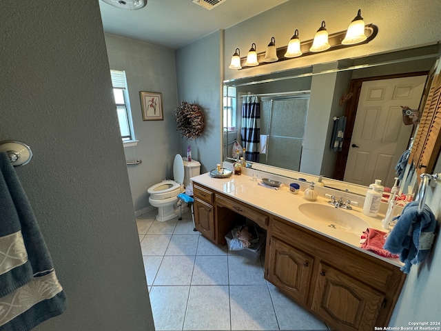 bathroom featuring tile patterned flooring, vanity, toilet, and walk in shower