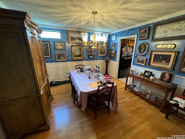 dining room featuring a chandelier, light hardwood / wood-style flooring, and ornamental molding