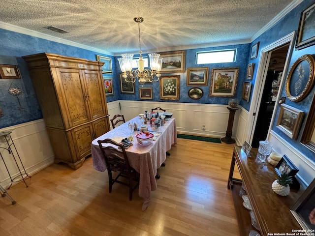 dining space with light hardwood / wood-style floors, an inviting chandelier, and crown molding