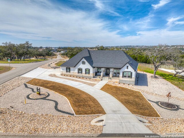 1207 Game Trl, New Braunfels, TX 78132 - french country home featuring stone siding, stucco siding, a shingled roof, and a yard