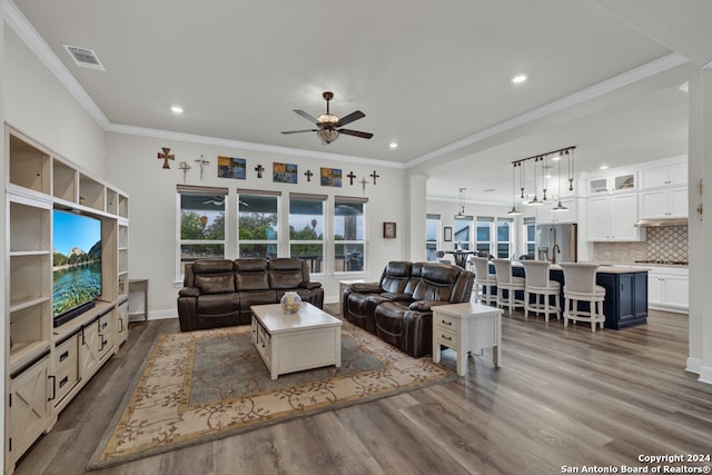 living area with ceiling fan, ornamental molding, dark wood-style flooring, and visible vents