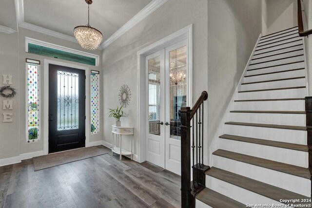 1207 Game Trl, New Braunfels, TX 78132 - foyer featuring french doors, crown molding, a chandelier, stairway, and wood finished floors