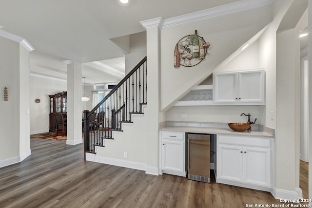 bar with baseboards, fridge, wood finished floors, and crown molding