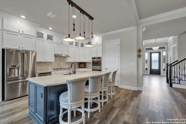 kitchen featuring visible vents, appliances with stainless steel finishes, light countertops, crown molding, and backsplash