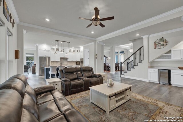 1207 Game Trl, New Braunfels, TX 78132 - kitchen with stainless steel appliances, a sink, blue cabinetry, white cabinetry, and ornamental molding