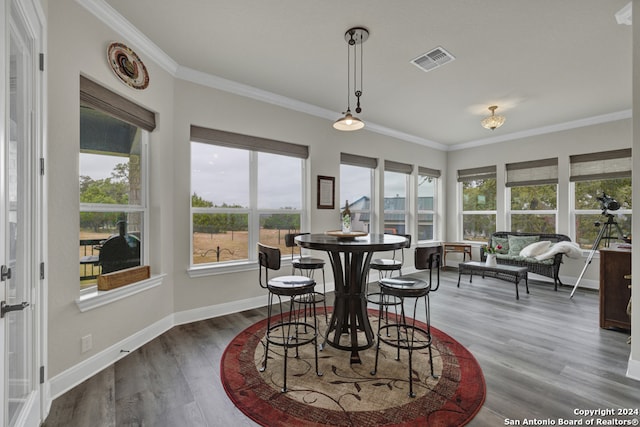 dining room featuring visible vents, crown molding, baseboards, and wood finished floors