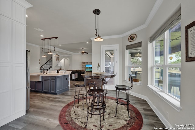 dining space featuring baseboards, stairway, wood finished floors, crown molding, and recessed lighting