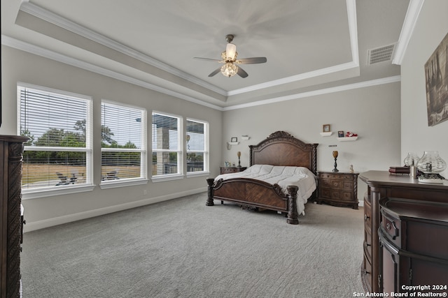 bedroom with carpet floors, baseboards, visible vents, and a raised ceiling