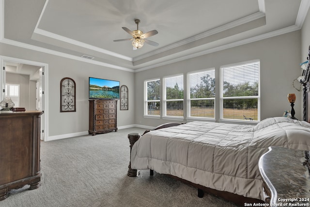 carpeted bedroom featuring baseboards, visible vents, a raised ceiling, a ceiling fan, and ornamental molding