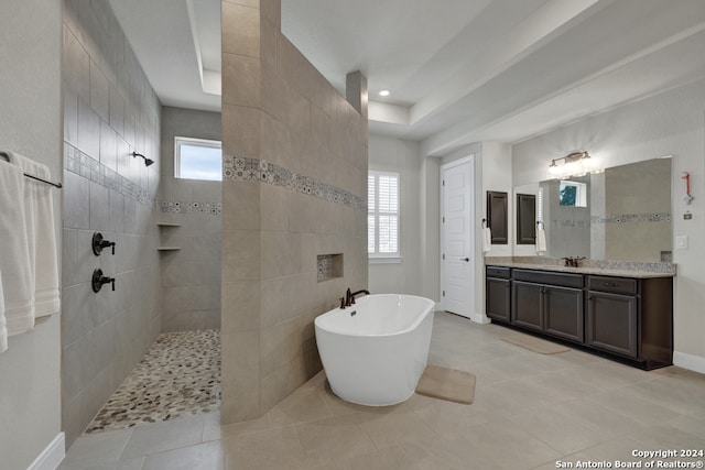 full bath featuring a freestanding bath, vanity, tile patterned flooring, baseboards, and walk in shower