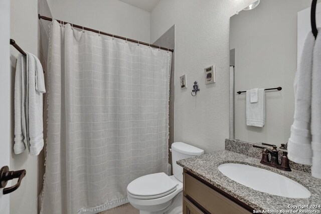 1207 Game Trl, New Braunfels, TX 78132 - full bath with toilet, vanity, a textured wall, and a shower with shower curtain