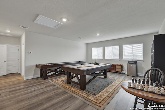 rec room with recessed lighting, visible vents, light wood-style floors, a textured ceiling, and baseboards