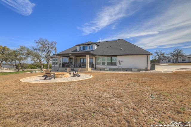 back of house featuring a patio area, a yard, and a fire pit