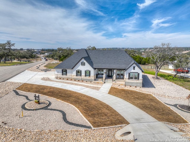 view of front of home featuring driveway, roof with shingles, and stucco siding