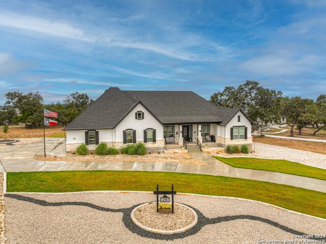 1207 Game Trl, New Braunfels, TX 78132 - view of front of home featuring a porch, a front lawn, roof with shingles, and stucco siding