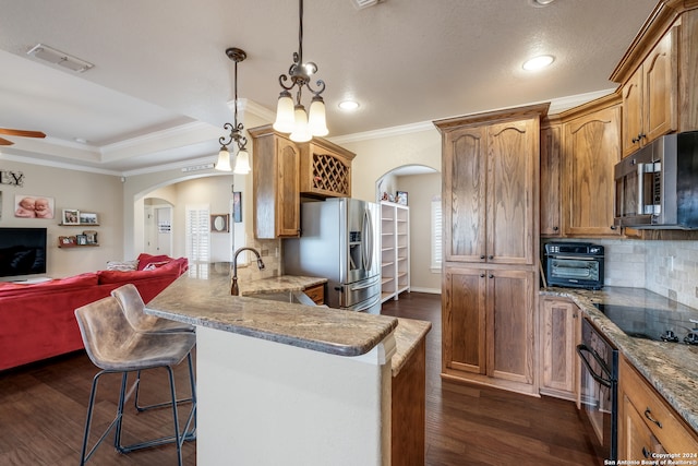 kitchen featuring kitchen peninsula, dark hardwood / wood-style floors, black appliances, and pendant lighting