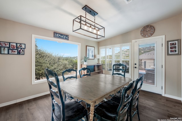 dining area featuring lofted ceiling and dark wood-type flooring