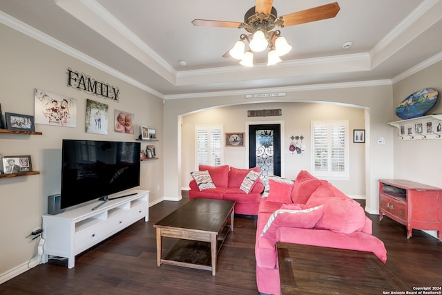 living room featuring dark wood-type flooring, ceiling fan, ornamental molding, and plenty of natural light