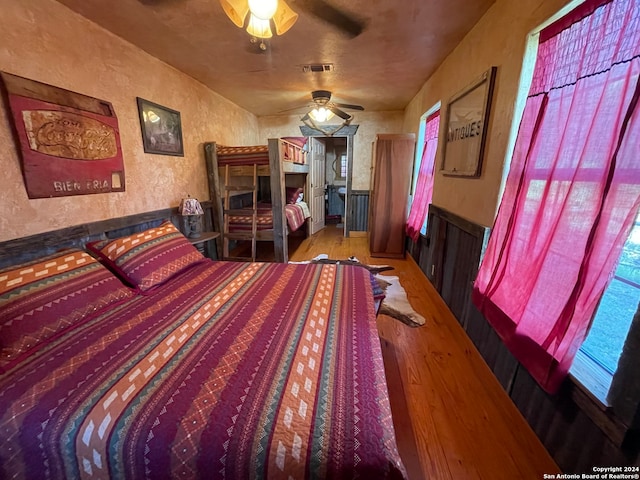 bedroom featuring ceiling fan, multiple windows, and hardwood / wood-style floors